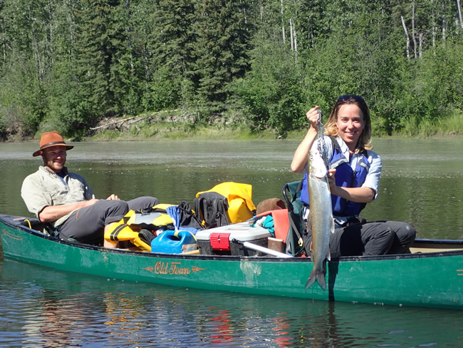 Alison Beamer displays a sheefish Jason Clark helped her land on the Zitziana River, which she paddled up on a Tanana River trip. Ned Rozell photo.